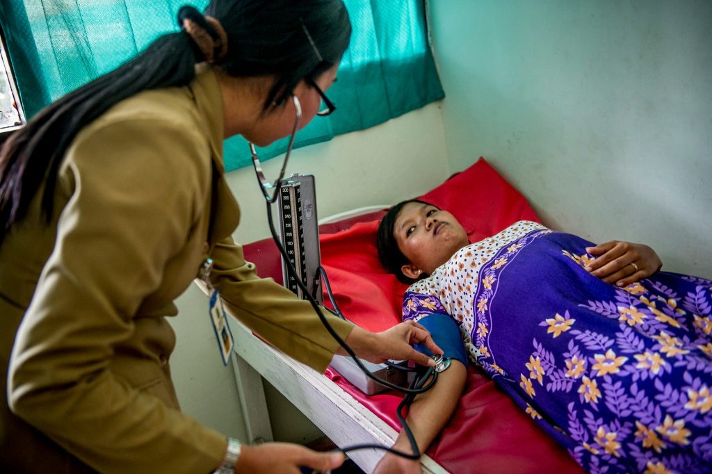 A health worker checks a pregnant woman's blood pressure.