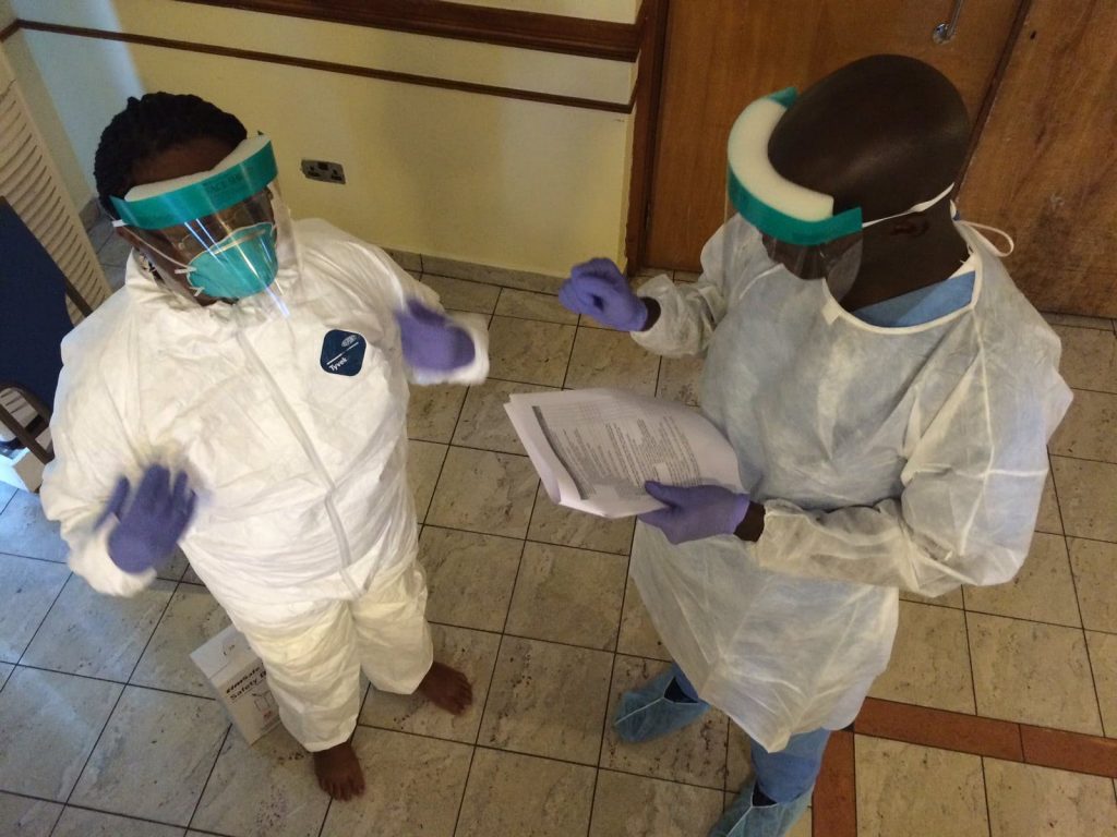 Two health workers in protective clothing.