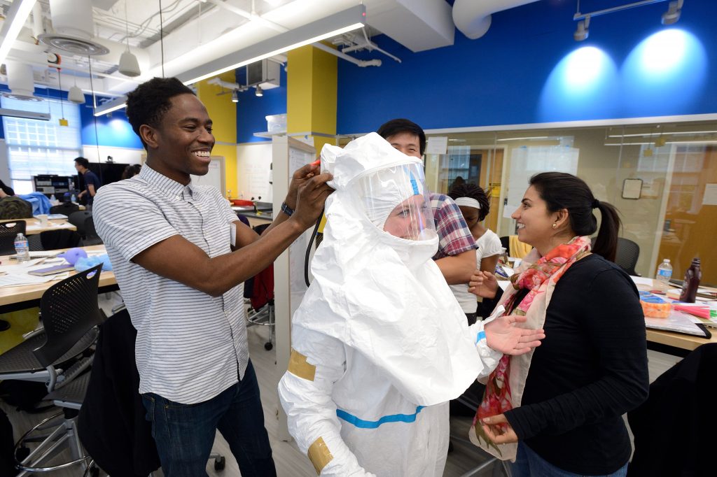 Participants in the Ebola Hackathon try on the suit.