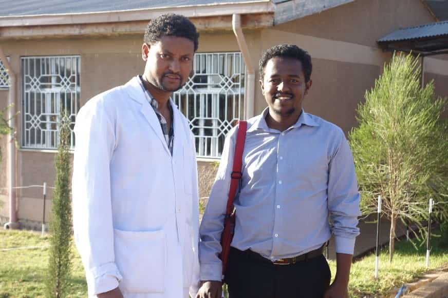Two men standing and smiling