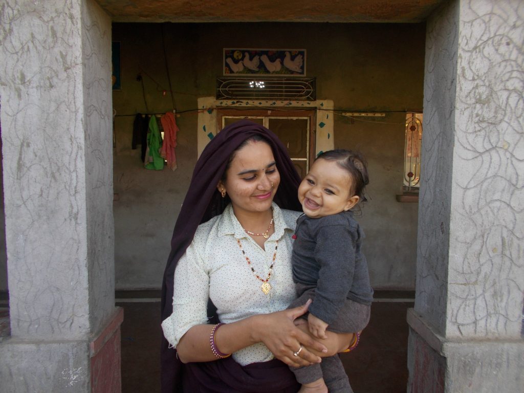 Woman smiling and holding toddler