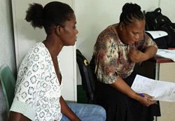 Two women sitting, looking at document