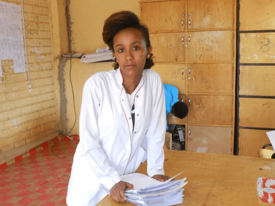 Woman standing with pile of papers