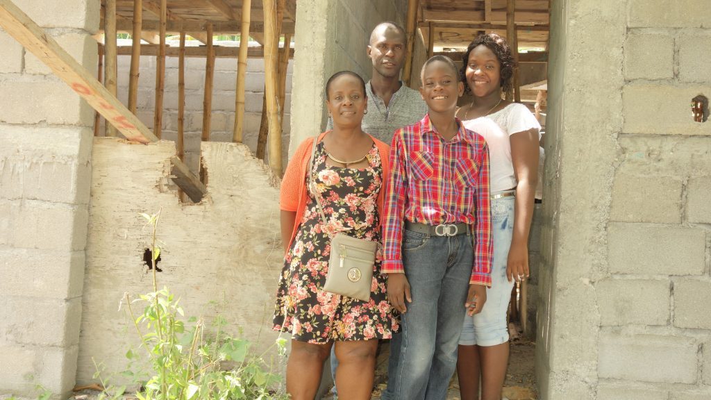 Four people standing and smiling