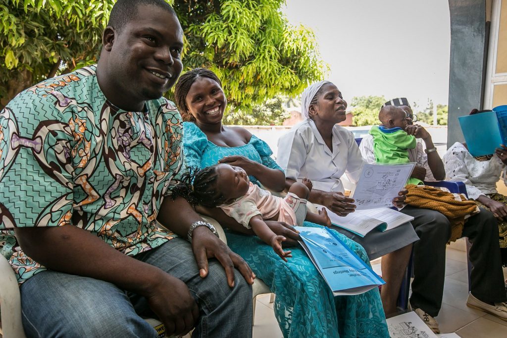 Men, women and children sitting and smiling