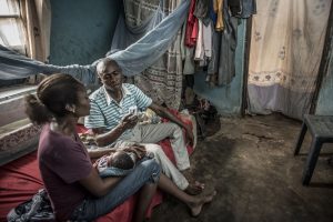 Woman and man sitting on bed with baby