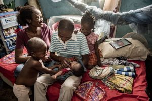 Man, woman and two children looking over baby man is holding