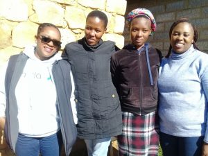 Four women standing and smiling