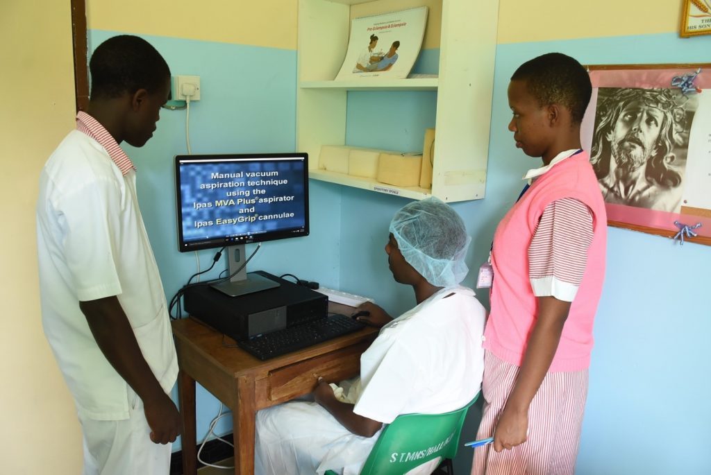 Three people looking at computer screen