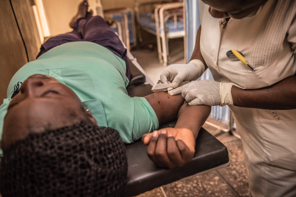 Woman laying on table with nurse standing over her and removing implant