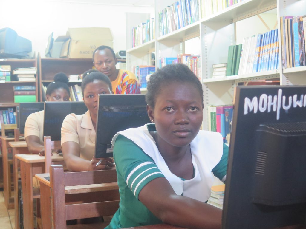 Women sitting at desks with computer screens. Photo by Emmanuel Attramah.