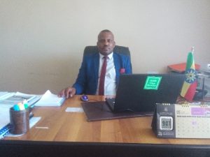 Man in suit and tie sitting at desk.