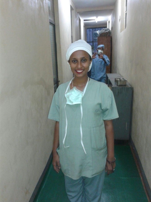 Woman in surgical scrubs and cap.