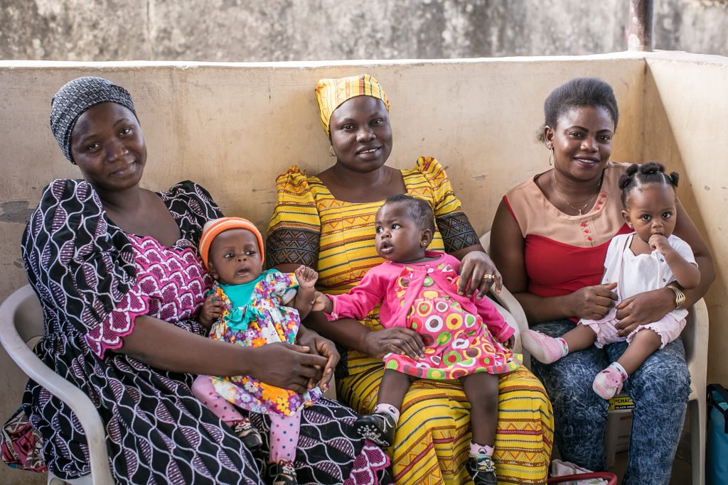 Three mothers sit with their babies