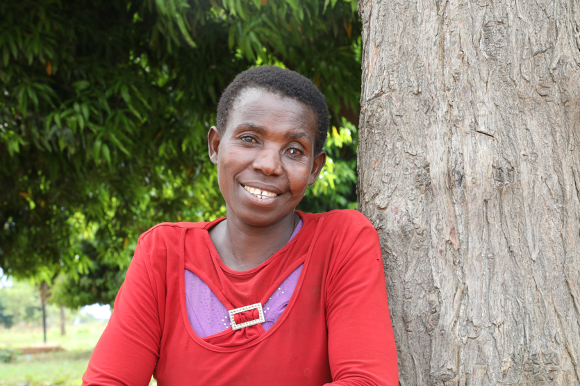 Woman leans against tree