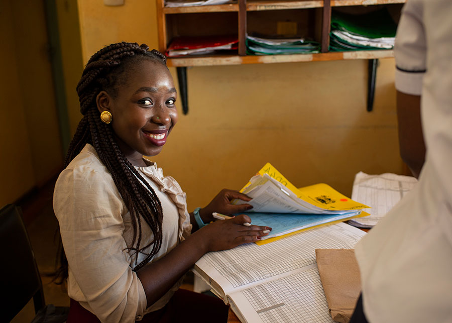 Smiling woman at desk going through paperwork