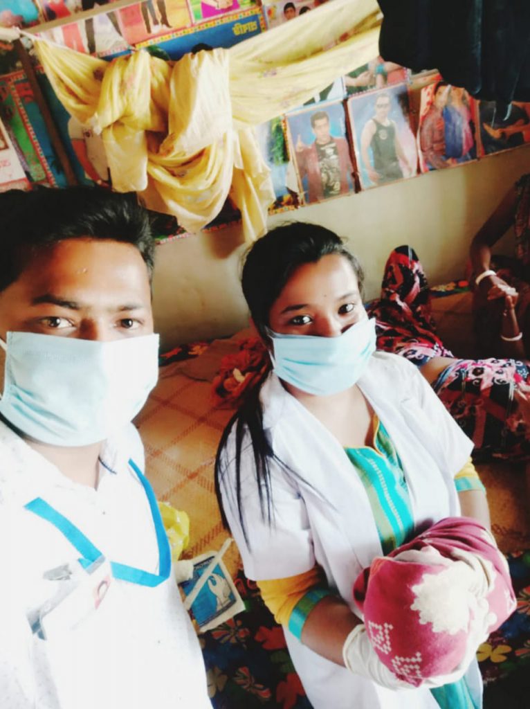 Nurses in protective gear with newborn